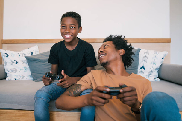 Father and son playing video games together at home. - Photo, Image