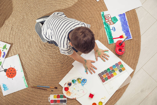 Little child painting on floor at home, top view - Photo, image