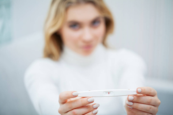 Vrouw voelt gefrustreerd over negatieve test van de zwangerschap - Foto, afbeelding