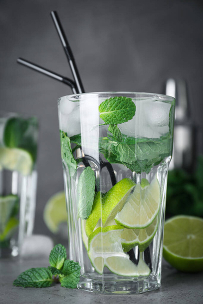 Glass of fresh Mojito cocktail on grey table, closeup - 写真・画像