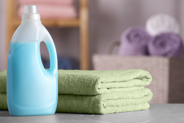 Folded clean towels and detergent on table in bathroom - Foto, immagini