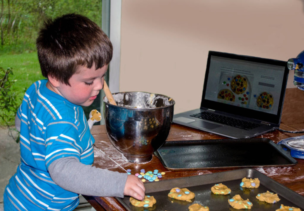 menino faz biscoitos com um laptop
 - Foto, Imagem