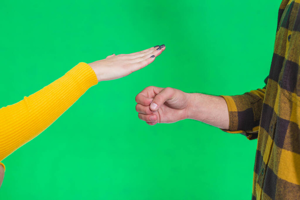 Cropped hands of people playing rock paper scissors isolated on green background. - Фото, зображення