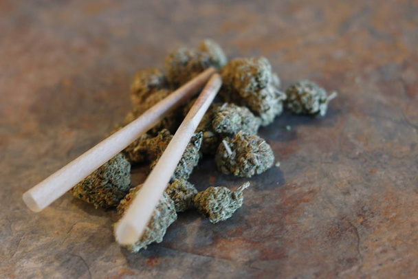 closeup of dried marijuana and handmade cigarette in ashtray. - Photo, Image