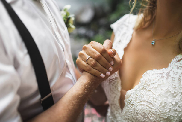 Bräutigam und Braut halten Händchen. Symbol für Liebe und Komma - Foto, Bild