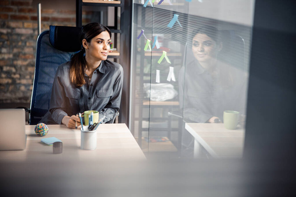 Cute brunette woman sitting at her workplace - Foto, immagini