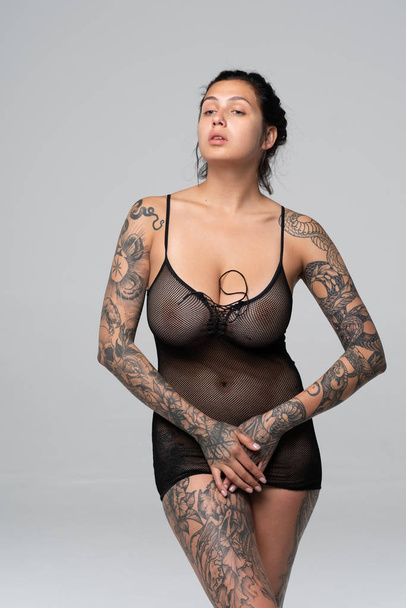 young beautiful girl pose nude in studio standing in black lingerie - Foto, imagen