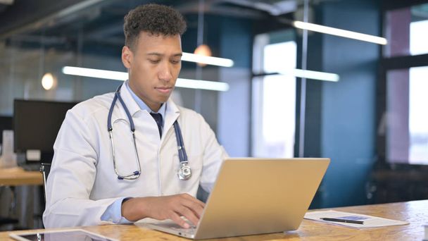 Fókuszált fiatal orvos dolgozik Laptop a modern irodában - Fotó, kép