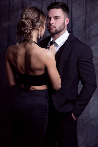 Close up portrait of an elegant girl who lovingly adjusts her tie to her man in a formal suit - Foto, Bild