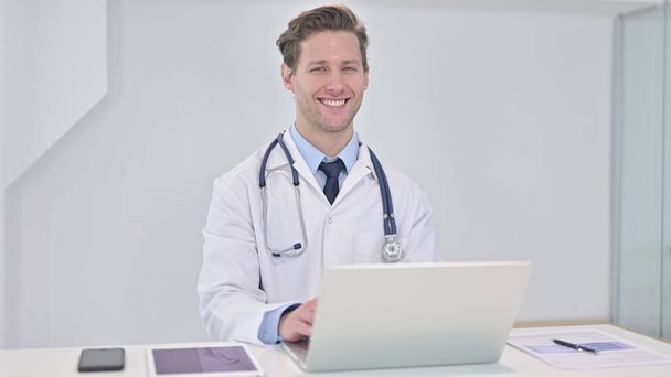 Cheerful Young Doctor Smiling at Camera in Clinic - Photo, Image