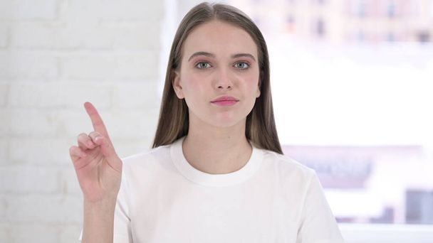 Porträt einer schönen jungen Frau, die per Fingergeste Nein sagt - Foto, Bild