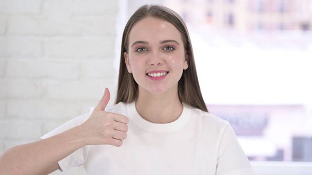 Portrait of Beautiful Young Woman doing Thumbs Up in Office - Fotografie, Obrázek