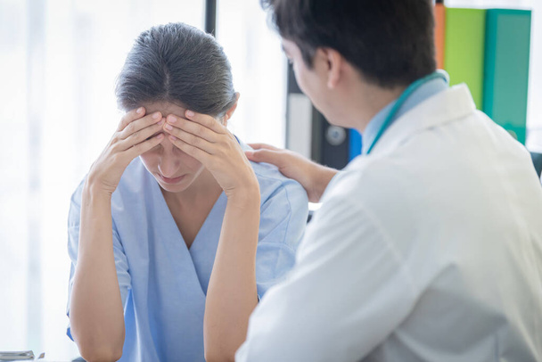Un médecin prend soin d'une patiente malade qui souffre de tristesse et de dépression - Photo, image