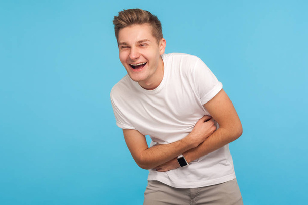 Hilarious joke! Portrait of laughing man holding his stomach and - Foto, Bild