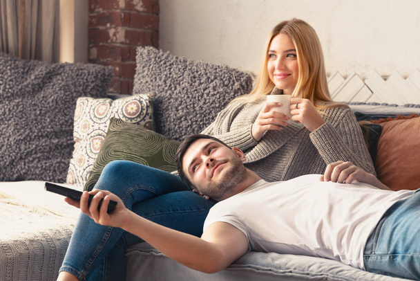 Jeune couple heureux se détendre à la maison et regarder la télévision
 - Photo, image