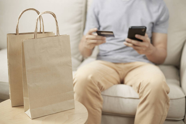Homem compras on-line usando smartphone e cartão de crédito e carteira um
 - Foto, Imagem