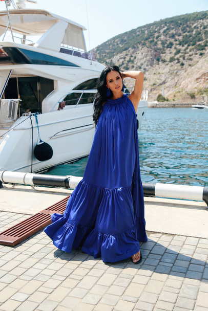 beautiful woman with dark hair in elegant dress posing near luxu - Фото, зображення