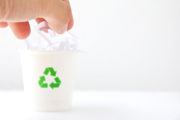 Deje caer papel triturado a mano en la papelera de reciclaje
 - Foto, Imagen