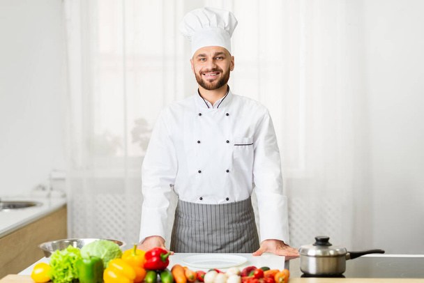 Chef masculin en uniforme souriant debout dans la cuisine
 - Photo, image