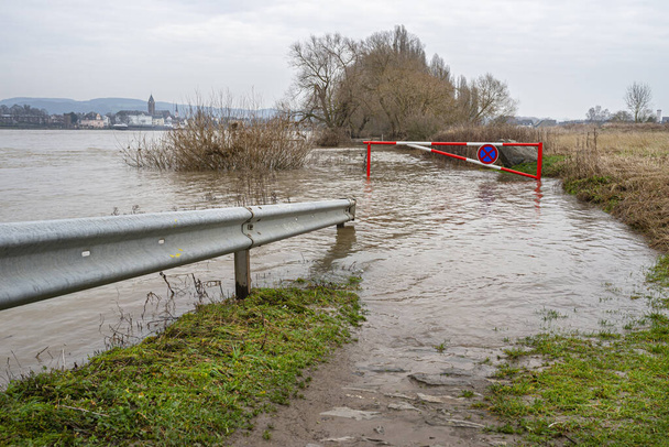 der hohe Zustand des Rheins in Westdeutschland, der aus dem Flussbett, dem überfluteten Geh- und Radweg hervorging. - Foto, Bild
