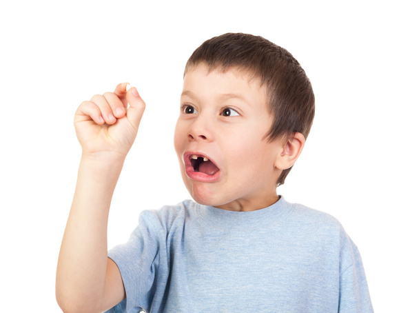 grimacing boy looks at lost tooth - Foto, afbeelding