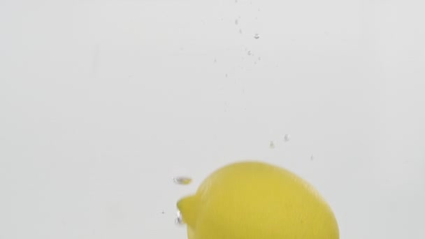 Slow motion. Lemon falling into water and floating in underwater. - Imágenes, Vídeo