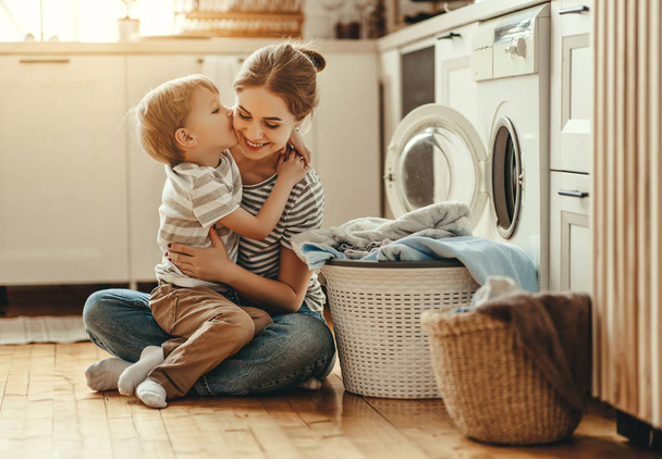 Feliz familia madre ama de casa y el niño en la lavandería con lavabo
 - Foto, imagen