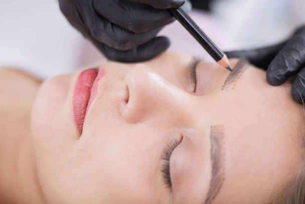 Cosmetologist applying permanent make up on eyebrows - Valokuva, kuva