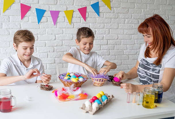 Happy family making Easter craft coloring eggs - Foto, imagen