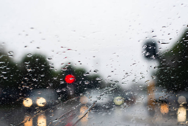 Erős esőzés a szélvédőn keresztül. A fényszórós autók alig látszanak az úton. Szelektív fókusz - Fotó, kép