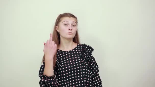 lány egy fekete ruha fehér körökben ideges dühös nő mutatja középső ujj - Felvétel, videó