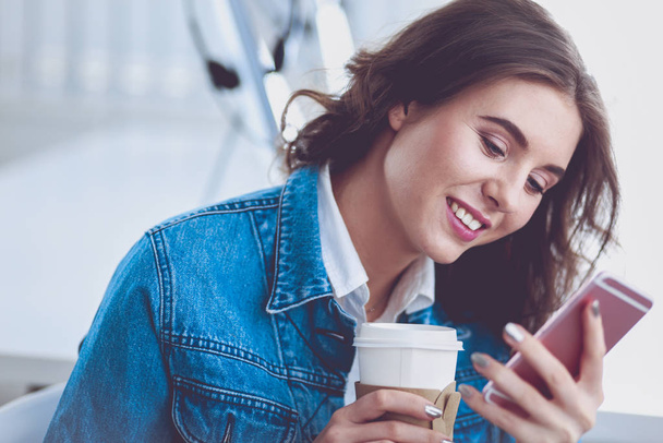 Mujer joven en la cafetería bebiendo café y hablando por teléfono móvil - Foto, imagen