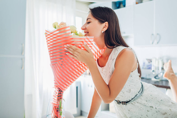Valentines day, Womens day.Woman smelling bouquet of flowers at home. Gift, present from boyfriend. Allergy free - Photo, Image