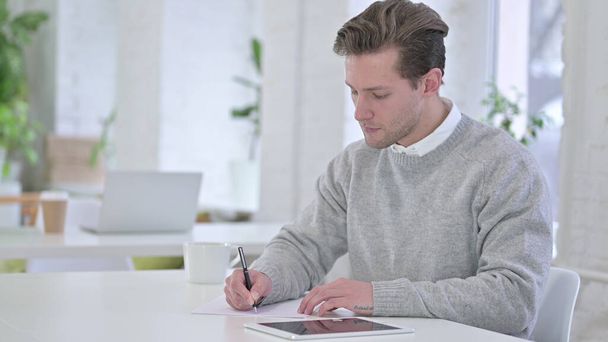 Creative Young Man doing Paperwork in Loft Office - Photo, Image