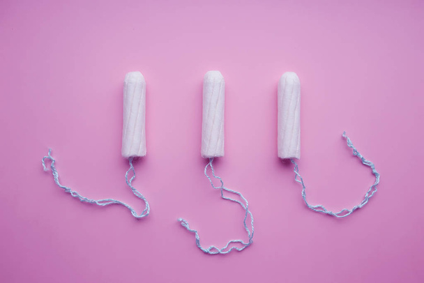 Damskie tampony medyczne na różowym tle. Biały tampon dla kobiet. Menstruacja, środki ochrony. - Zdjęcie, obraz