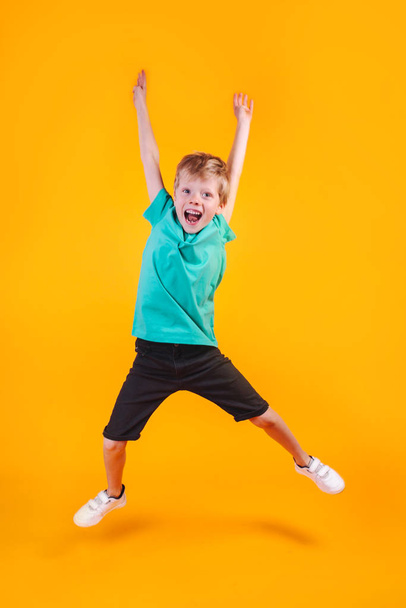 Portrait of jumping funny boy on color background - Fotoğraf, Görsel