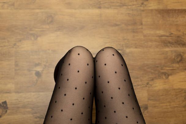 Sedutor feminino modelo pernas em meias pretas vista superior
 - Foto, Imagem