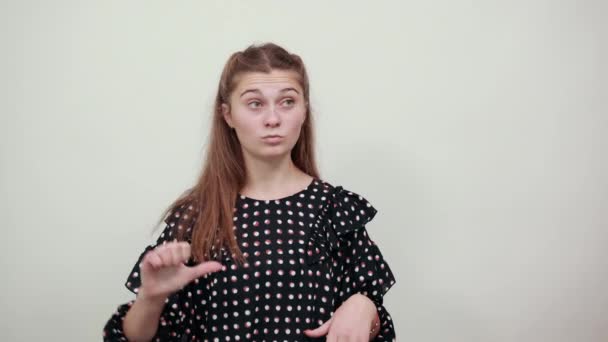 meisje in een zwarte jurk boos ontevreden vrouw afgewezen haar duimen in slecht humeur - Video