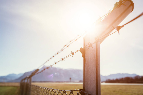 Military fence, demarcate the border, closeup, blurry background - Foto, afbeelding