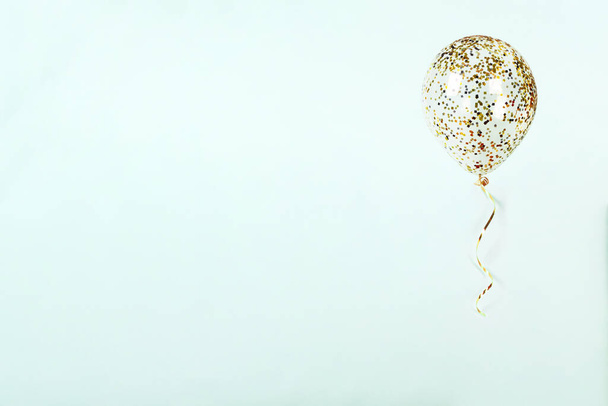 fliegender Ballon mit goldglänzendem Konfetti und Band auf hellblauem Hintergrund. funkelt Tapete Dekor. Alles Gute zum Geburtstag, Valentinstag, Hochzeitseinladung Postwagen Hintergrund. - Foto, Bild