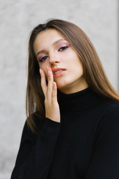 A girl in black clothes touches her lip with her finger, herpes  - Foto, Bild