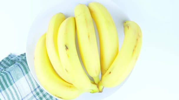 Banán egy tányéron, fehér háttérrel. Étel. Gyümölcs. Videó. - Felvétel, videó