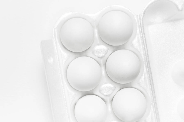 weiße Hühnereier in weißer Verpackung auf hellem Hintergrundbild flach legen Kopierraum. Eier in Schachteln, natürliche gesunde Ernährung und ökologischer Landbau. kreatives Essen minimalistischer Hintergrund, Ostern - Foto, Bild