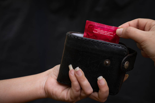 Szekrény nő kéz kezében fekete bőr pénztárca egy piros lakás - Fotó, kép