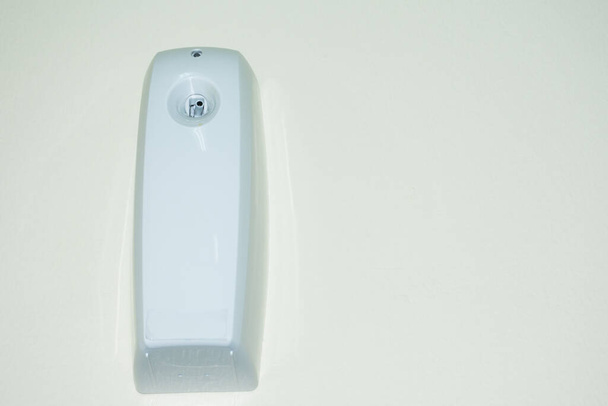 dispensador de aerosol de olor aromático en la pared en un temporizador para agregar fragancia en la casa u oficina
 - Foto, imagen