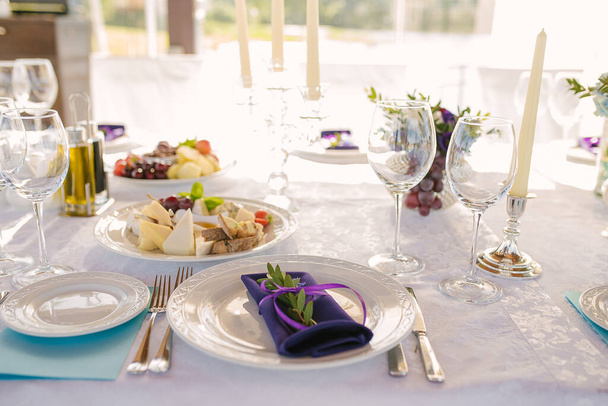 Escenario festivo de la mesa del banquete. Una servilleta púrpura yace en un
  - Foto, imagen