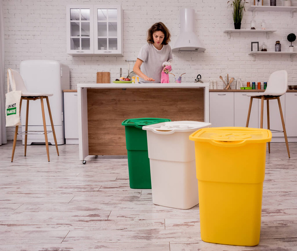 Young girl sorting garbage at the kitchen. Concept of recycling. Zero waste - Photo, image