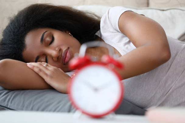 Женщина крепко спит, устанавливая будильник, пока
. - Фото, изображение