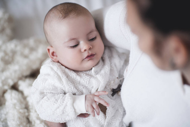 1歳未満のかわいい赤ちゃんの母親の手に部屋の閉鎖に横たわっている。おはようございます母親。産前.  - 写真・画像