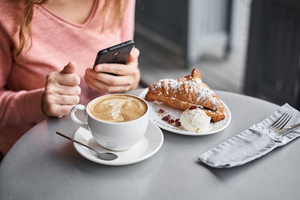 Woman have breakfast in caffe and using smartphone. Girl chattin - Photo, Image